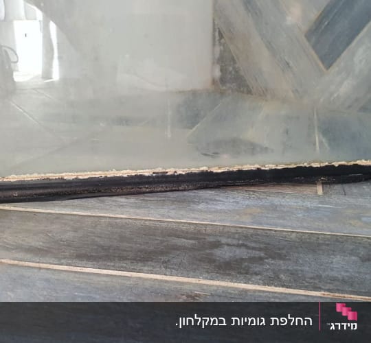 זכוכית עם מסגרת שחורה על רצפת עץ